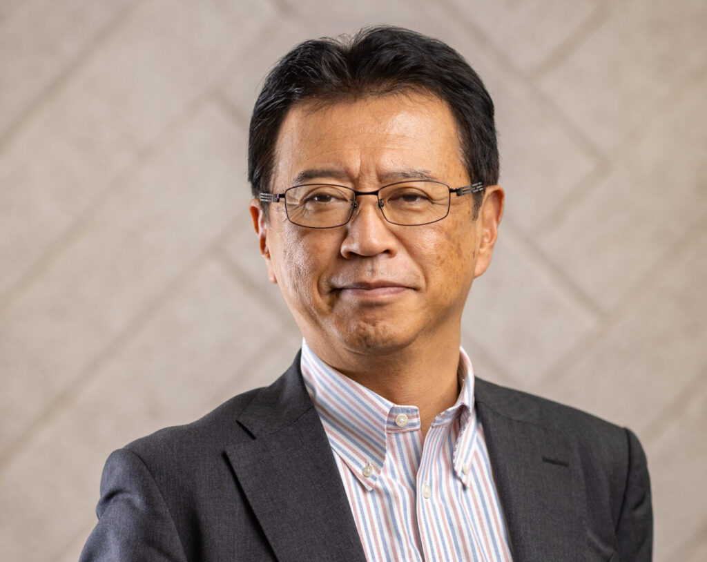 Portrait of a middle-aged man wearing glasses and a suit jacket