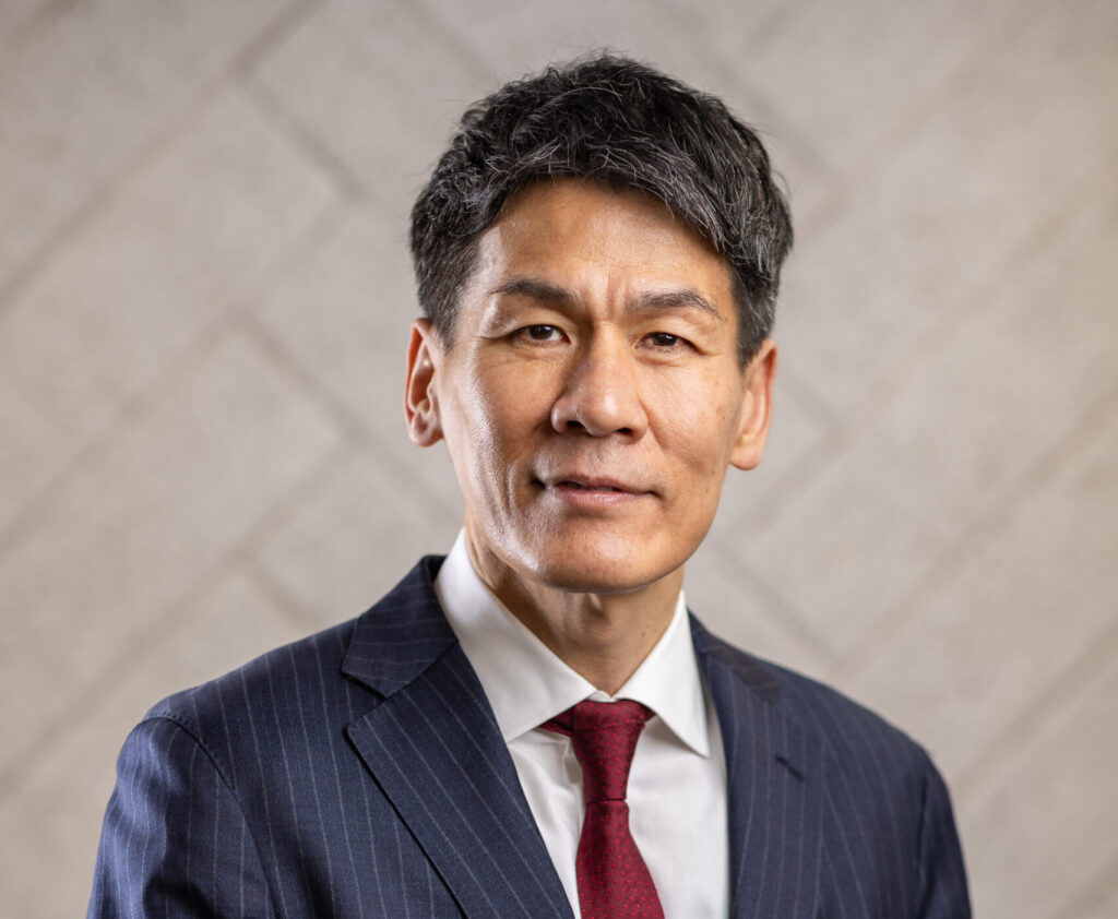 Professional portrait of Ken Matsuda in a suit and red tie